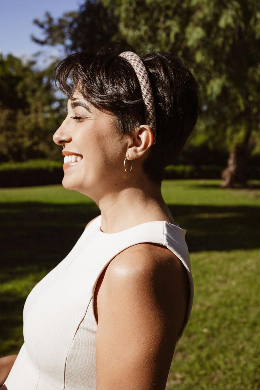 Grazielle de perfil, sorrindo de olhos fechados ao sol